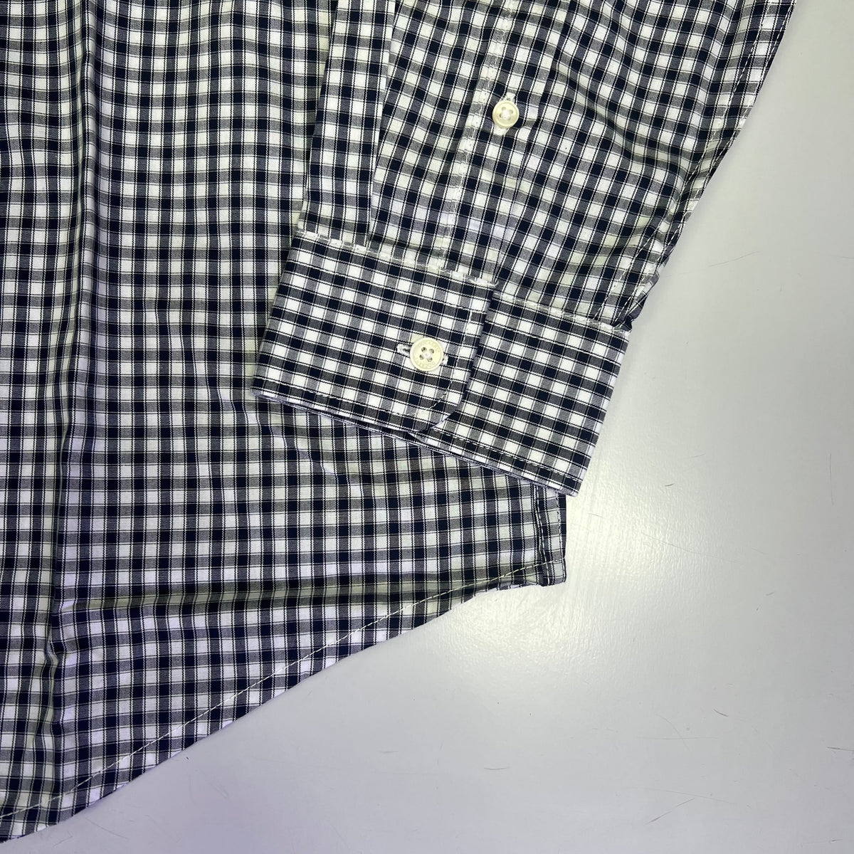 Men's plaid button-up shirt sleeve cuff with double-button placket, navy and white check