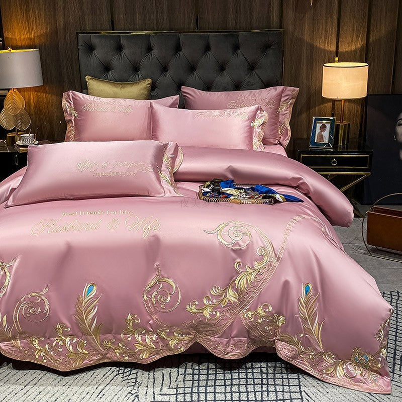 Pink quilted bed sheet set with gold and green ornate embroidery and matching pillowcases