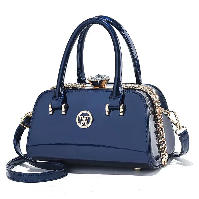 Sapphire blue patent leather handbag with top handles, chain strap, and diamond clasp