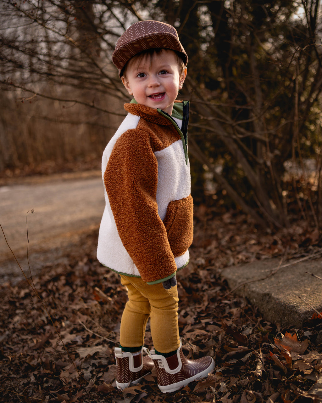 Brown-and-white sherpa pullover hoodie with green zipper and ribbed cuffs
