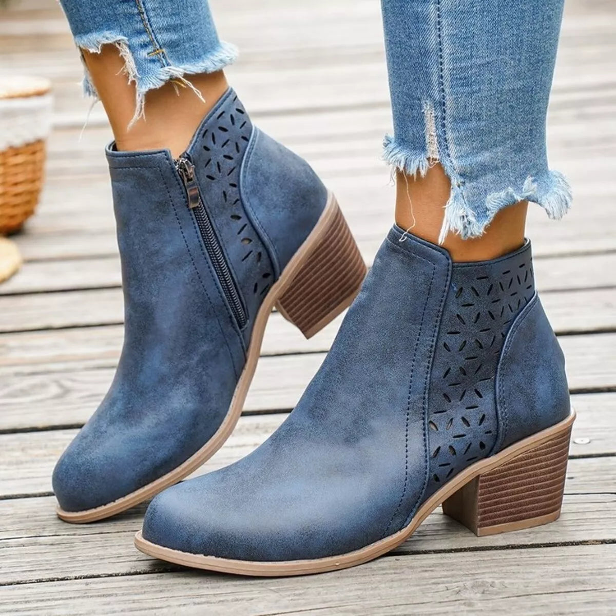Blue ankle boots with block heel, side cutout perforations, and zip closure