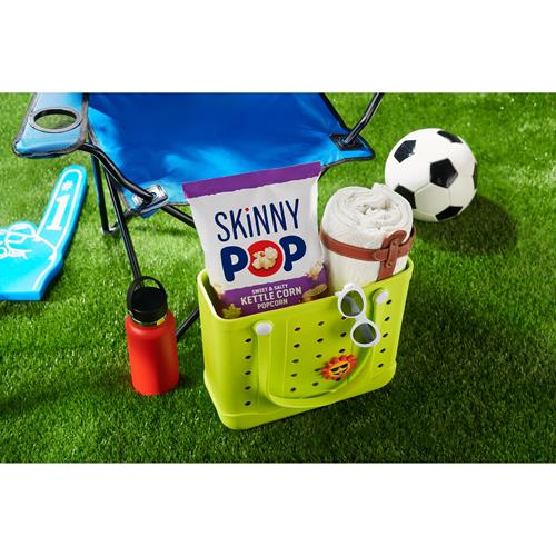 Skinny Pop kettle corn bag in a lime green basket with snacks