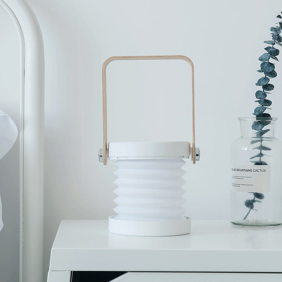 Foldable LED night light lantern with tan handle, ribbed white shade, blue base ring