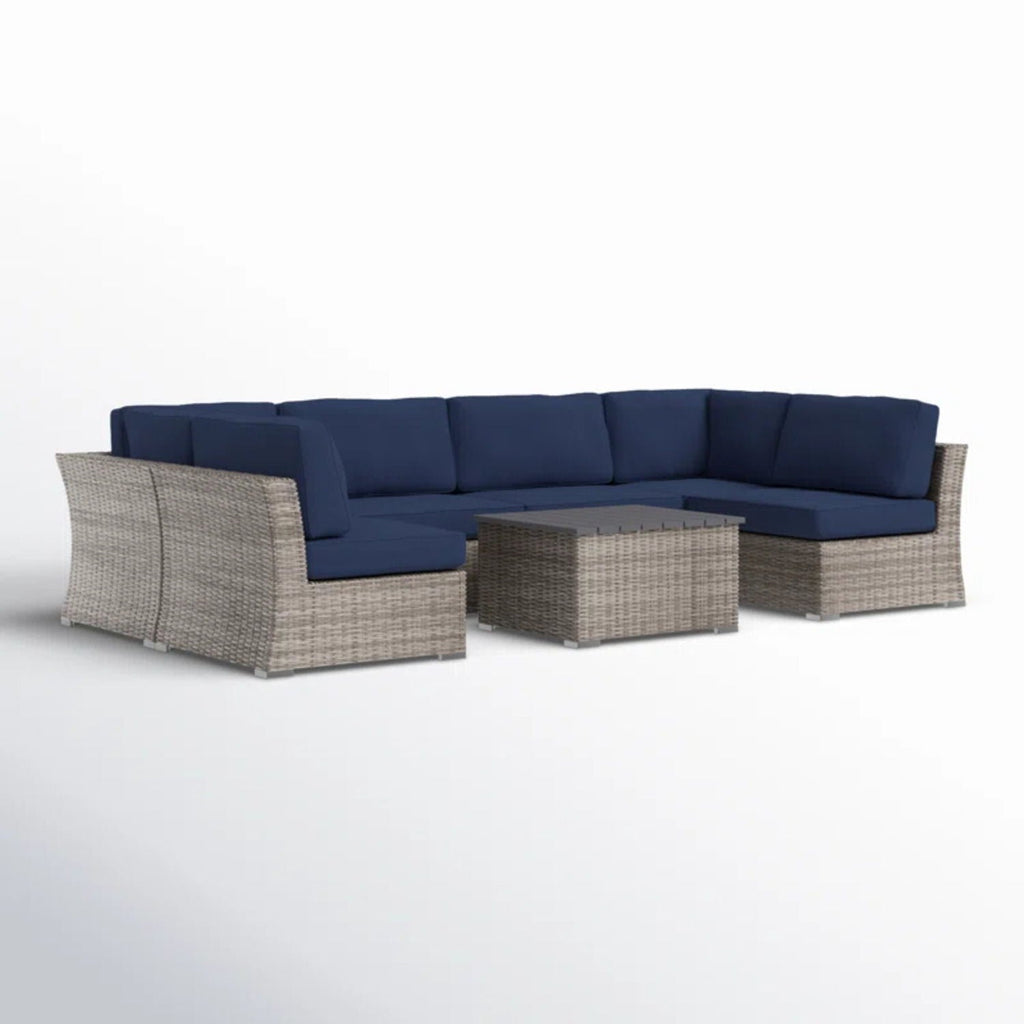Gray wicker sectional sofa with blue cushions and square coffee table