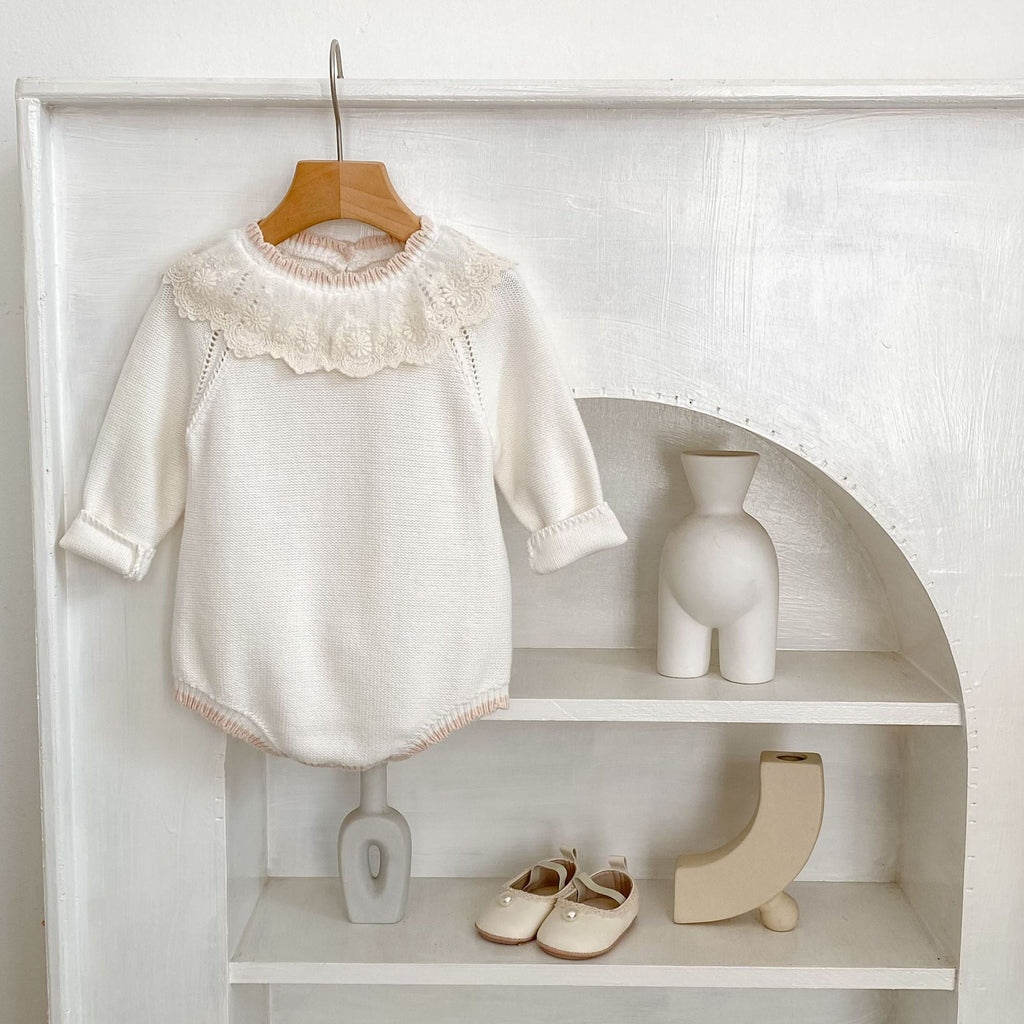 Off-white long-sleeve baby romper with raised lace collar and ribbed knit cuffs