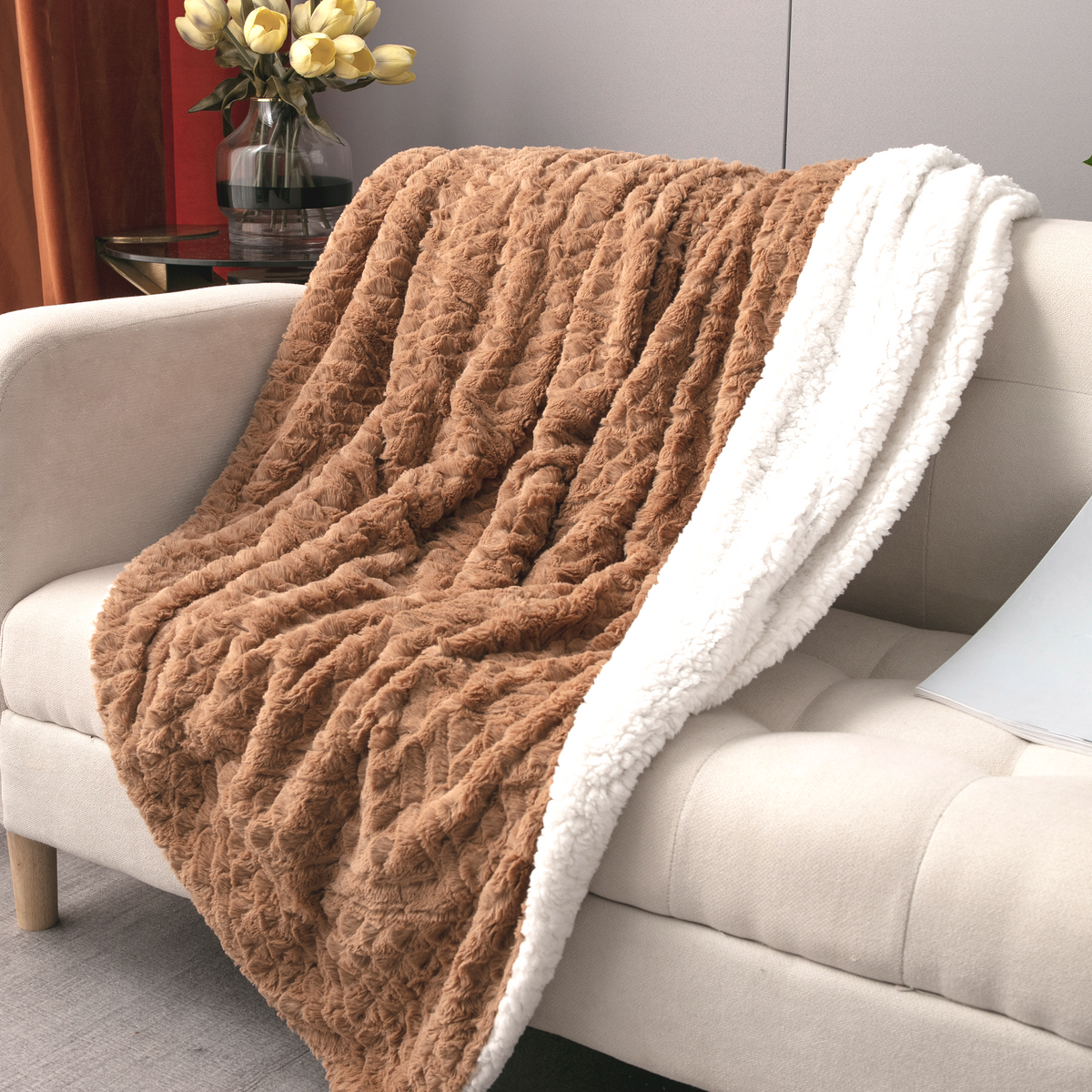 Caramel brown faux fur throw blanket with cream sherpa border over light sofa