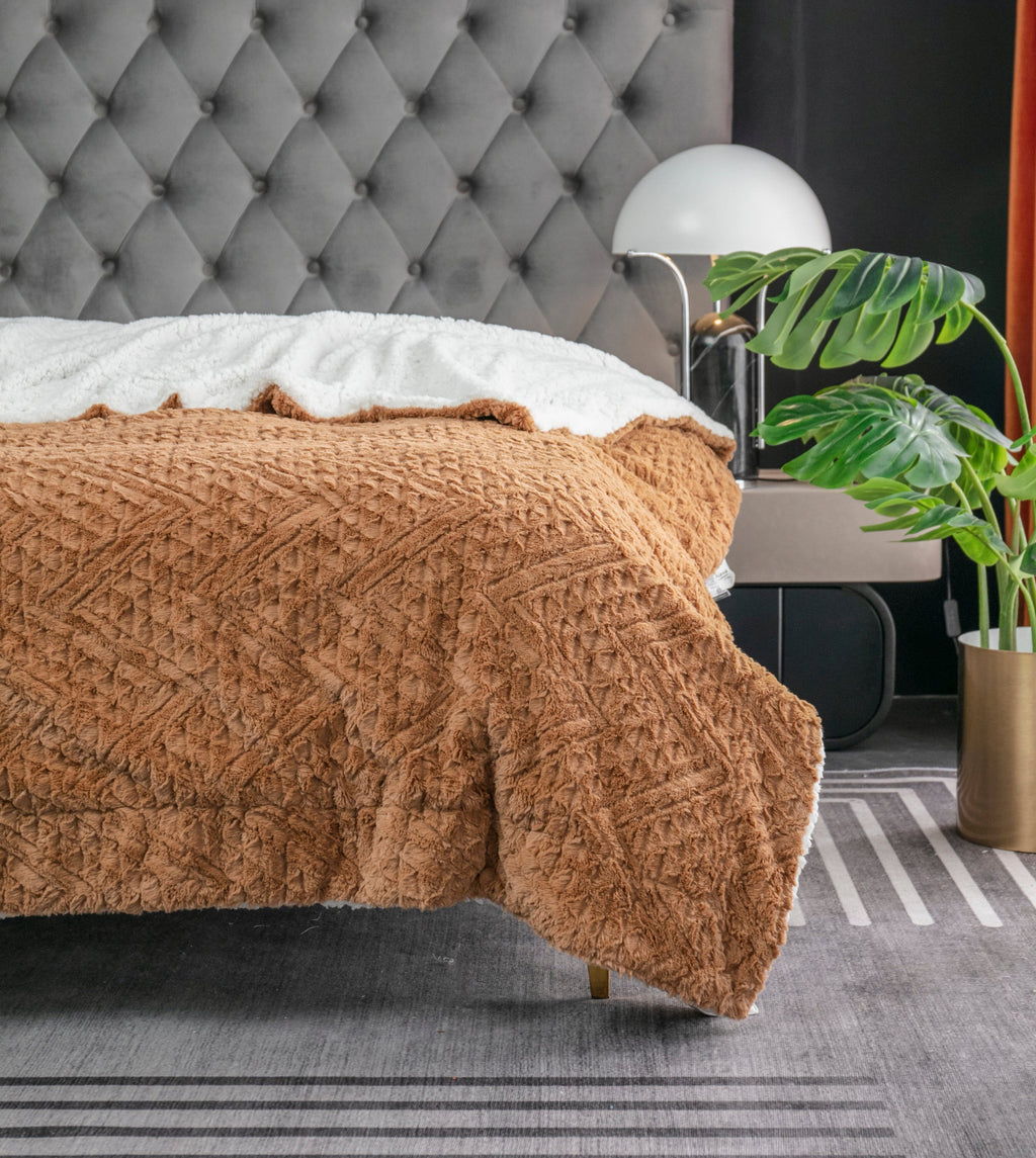 Caramel brown faux fur throw blanket with embossed chevron pattern and white backing