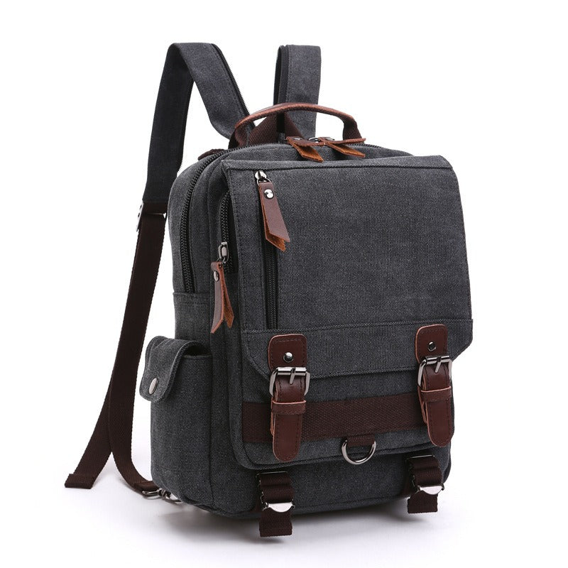 Dark gray canvas backpack with top handle, front buckled strap, and zipper pocket