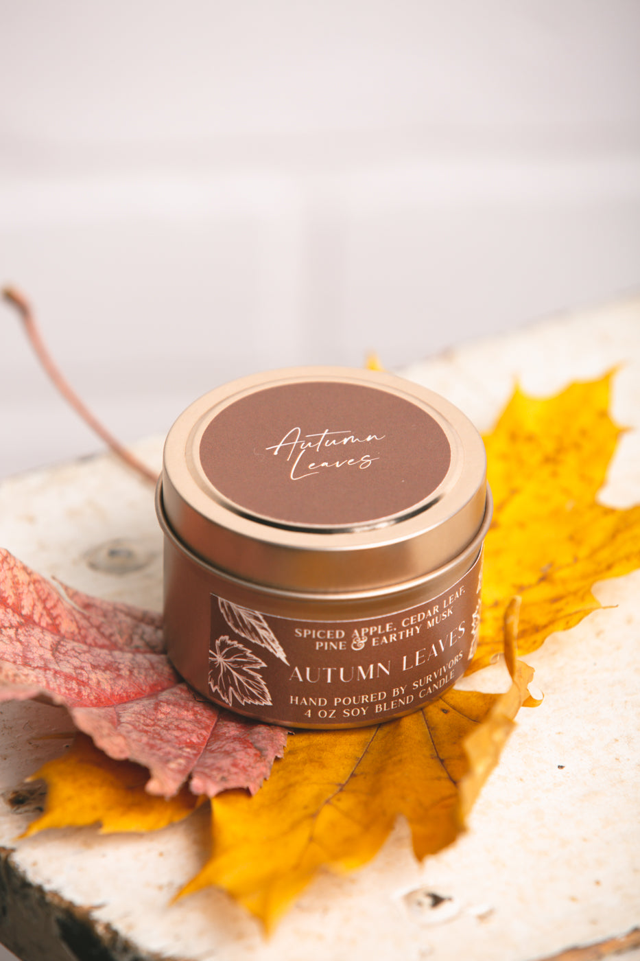 Autumn Leaves tin candle in a gold metal container with brown lid label