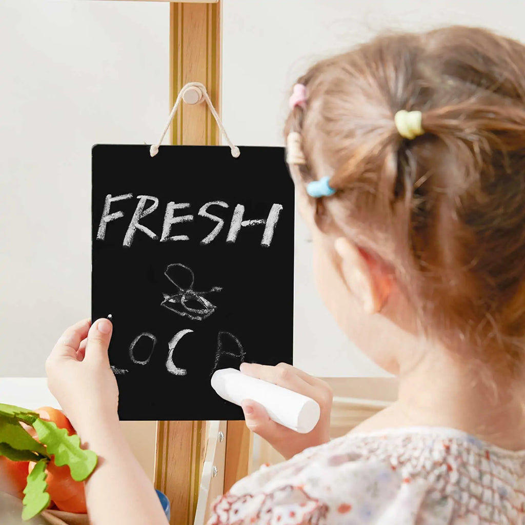 Tiny Land® playset chalkboard sign reading “FRESH & LOCAL” held by a child