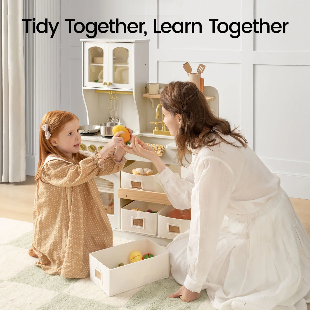 Wooden play kitchen with storage, cream cabinet and open drawers with toy food items