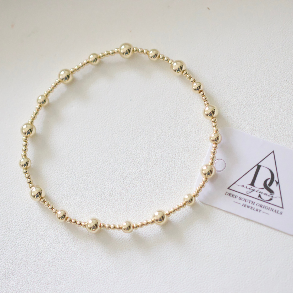 Gold-tone round-bead bracelet with a smooth circular strand