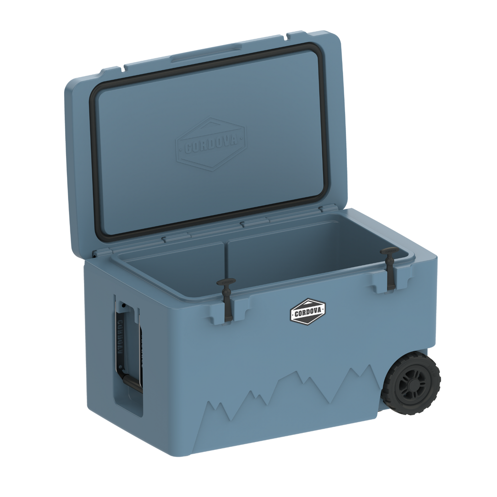Light blue 125 qt wheeled cooler with open lid and front latch, showing interior