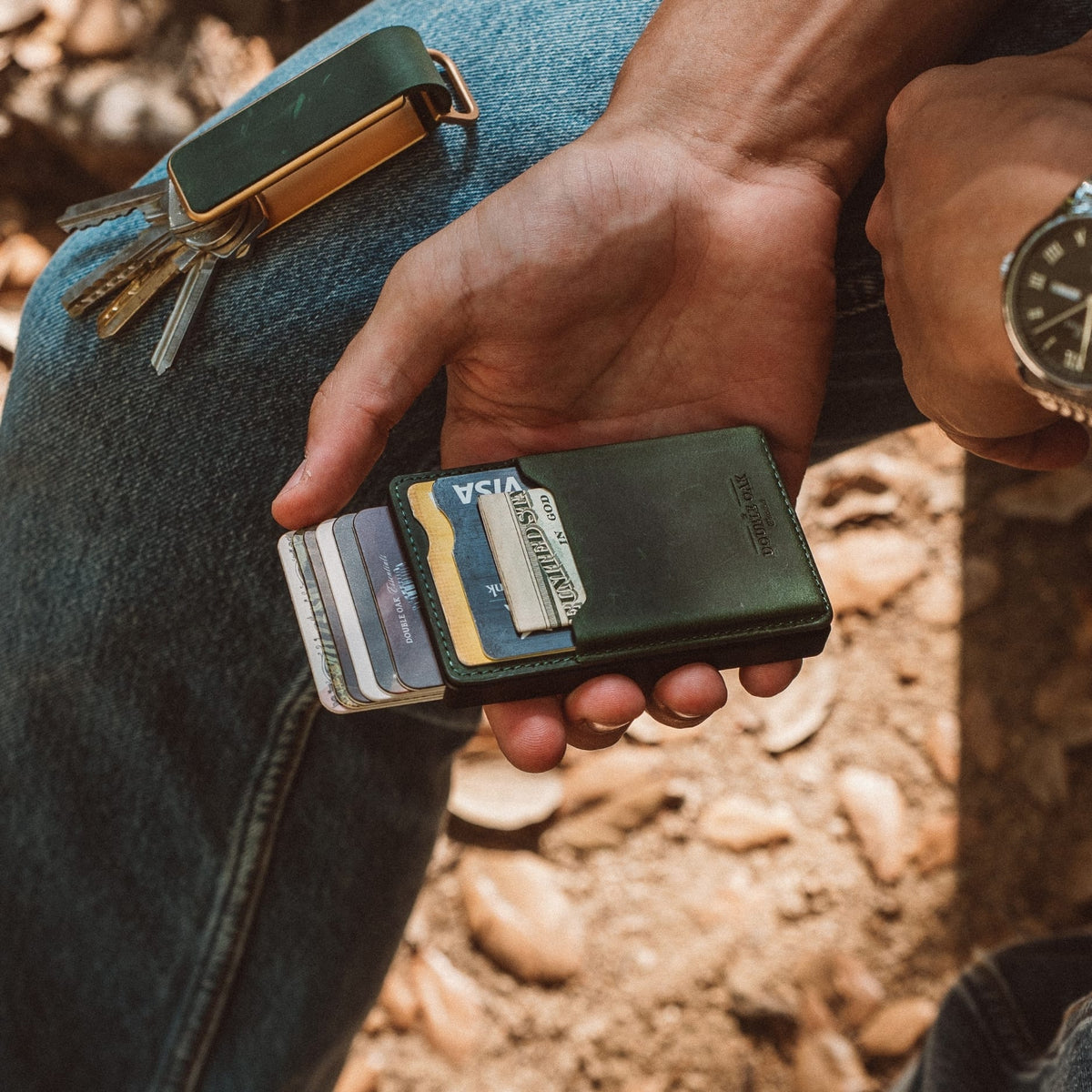 Green leather mod wallet held in hand with cards visible in front pocket