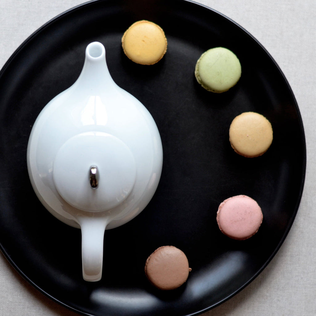 White ceramic teapot with infuser base and round lid, seen from above