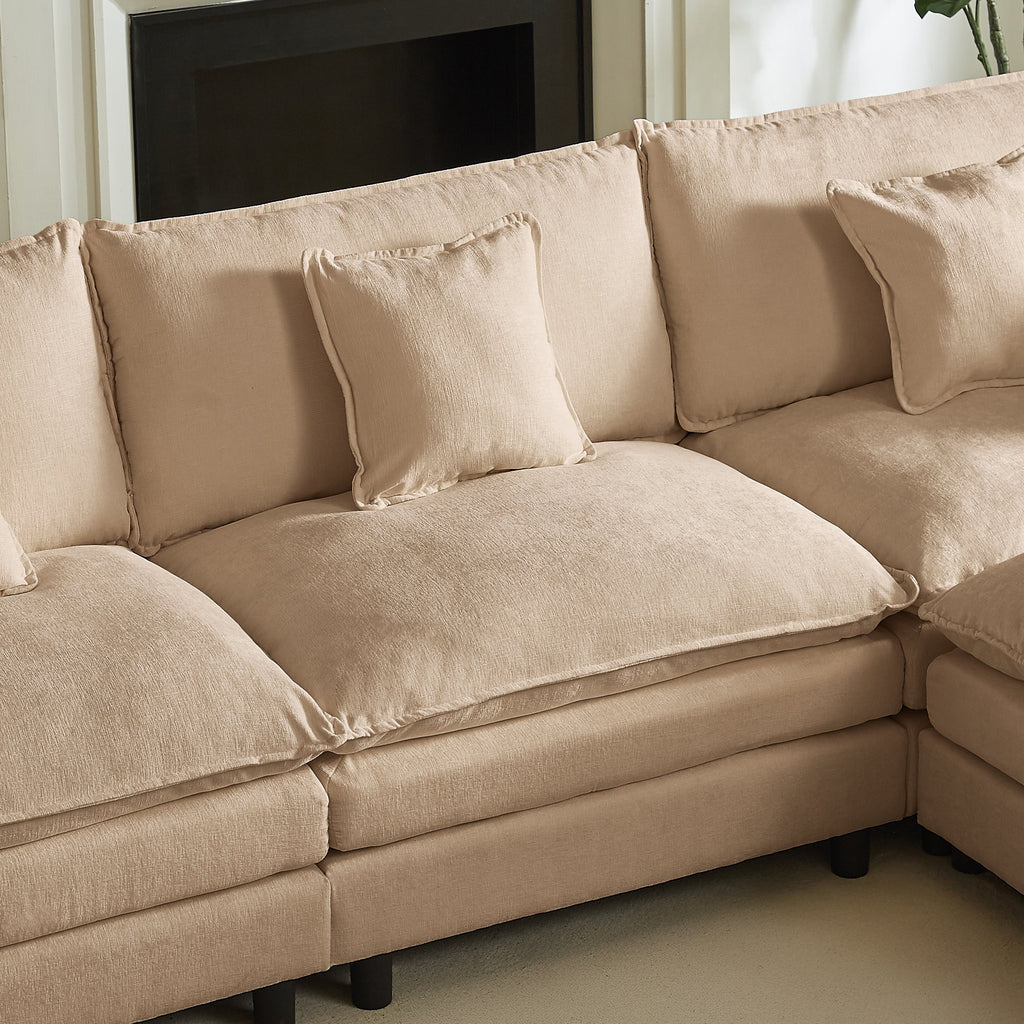 Beige chaise corner section with two seat cushions and three back pillows in soft upholstery.