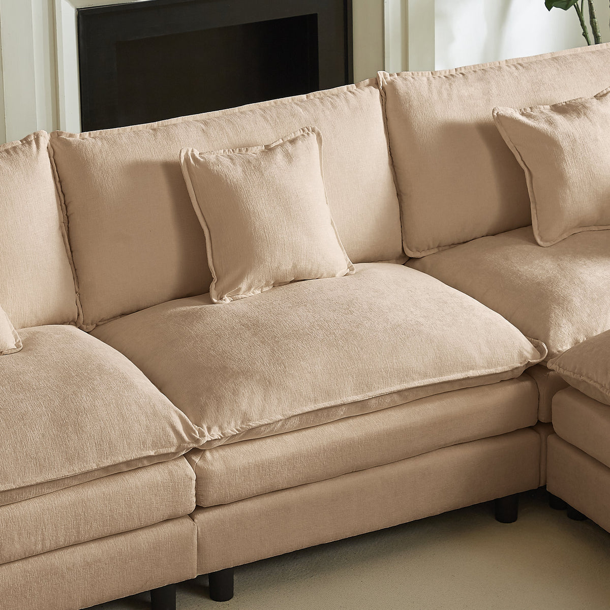 Beige chaise corner section with two seat cushions and three back pillows in soft upholstery.