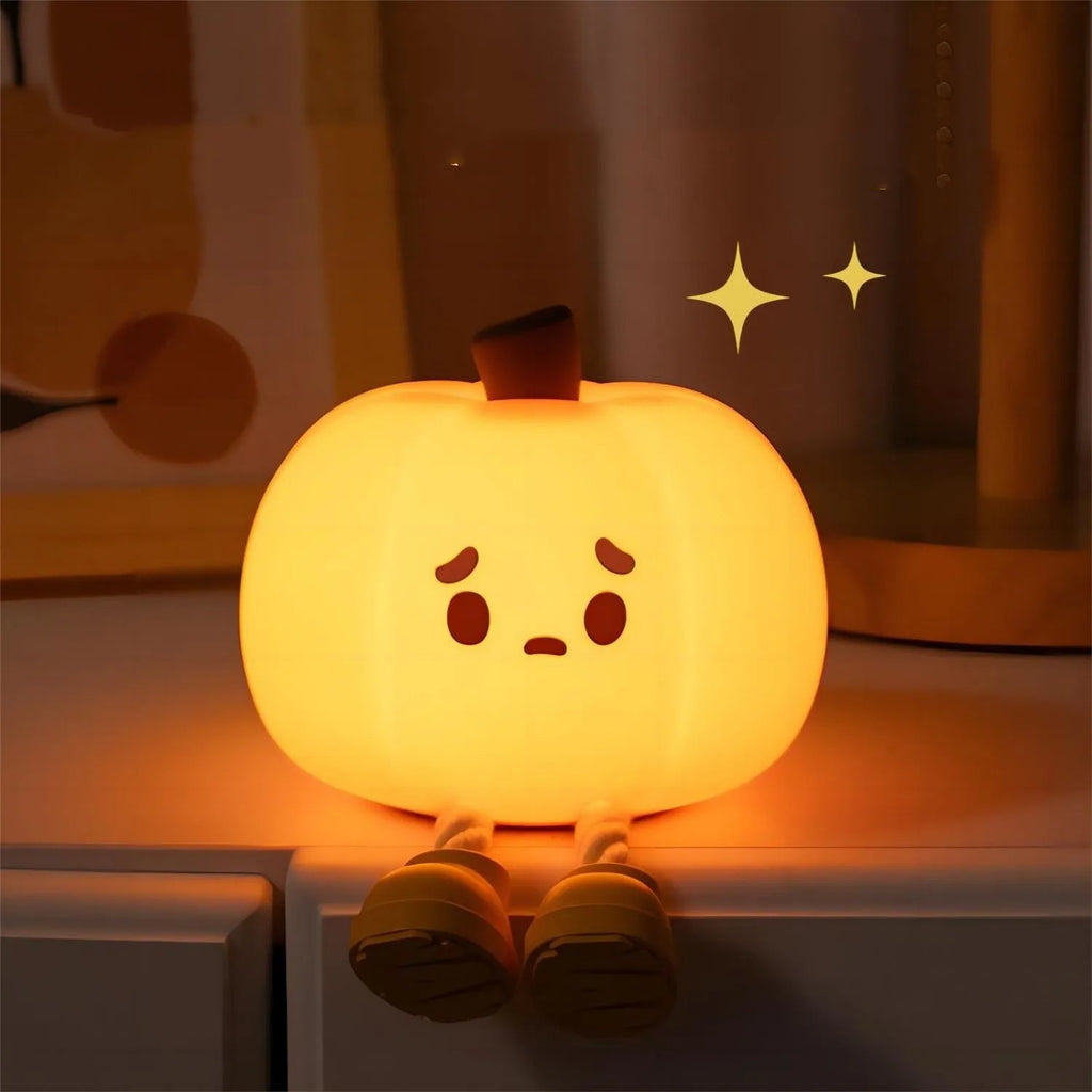 Silicone pumpkin night light with sad face, warm light on nightstand