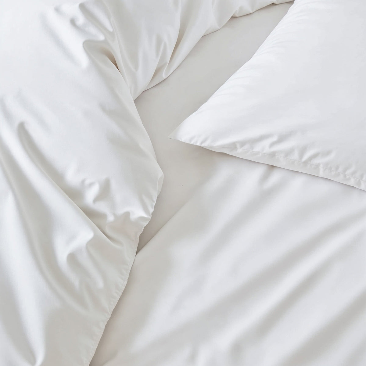Australian sateen sheet set in white, close-up of smooth fabric and pillowcase