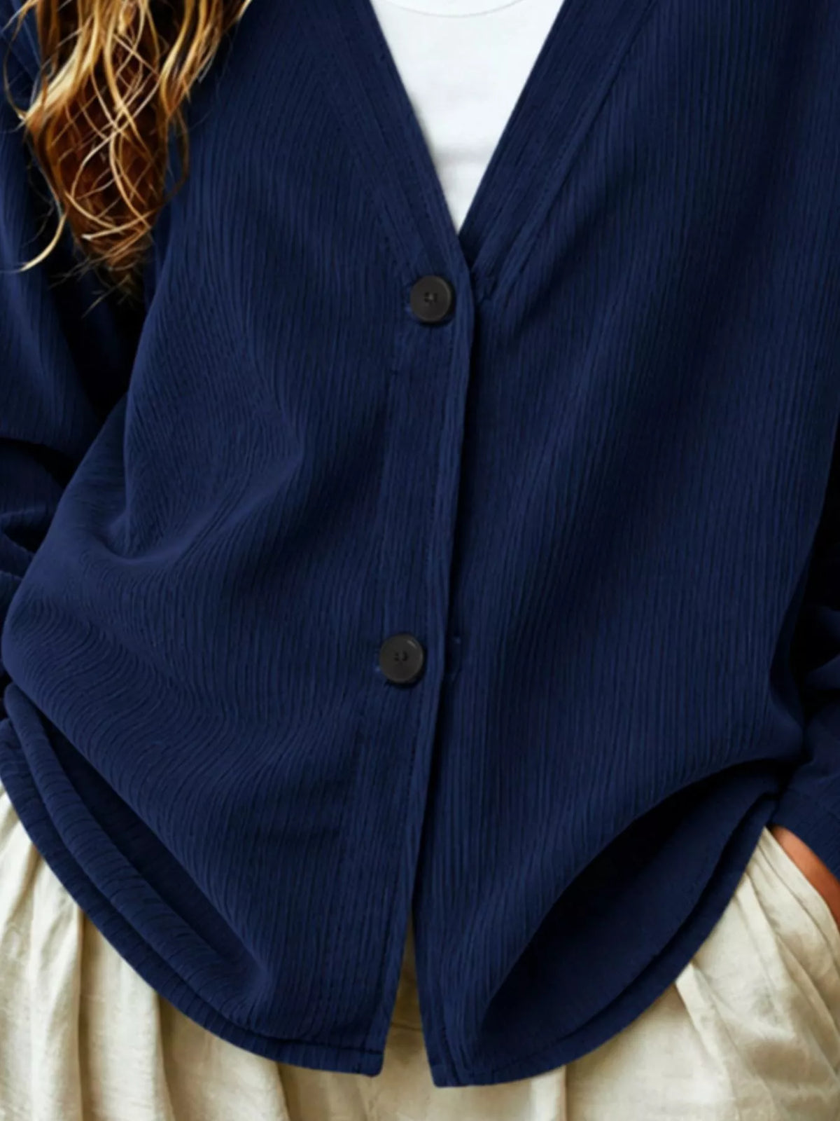 Dark blue corduroy cardigan close-up, V-neck, button front with two dark buttons