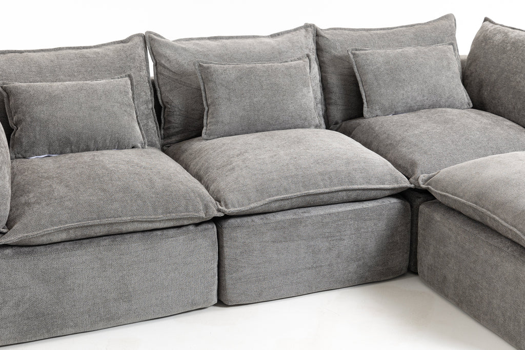 Close-up of gray sectional sofa cushions, seat, and back pillows with rounded arms
