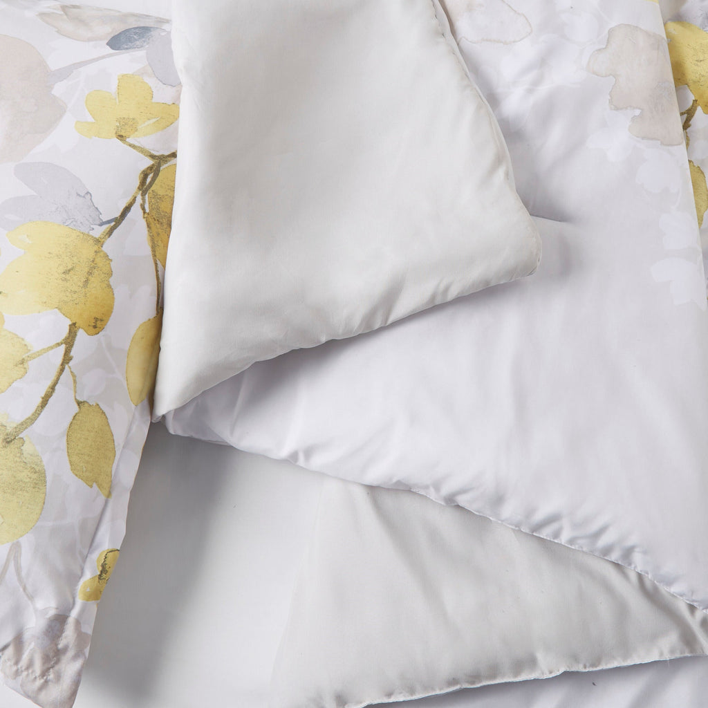 Close-up of Twin XL comforter and white pillow with multicolor yellow floral accents