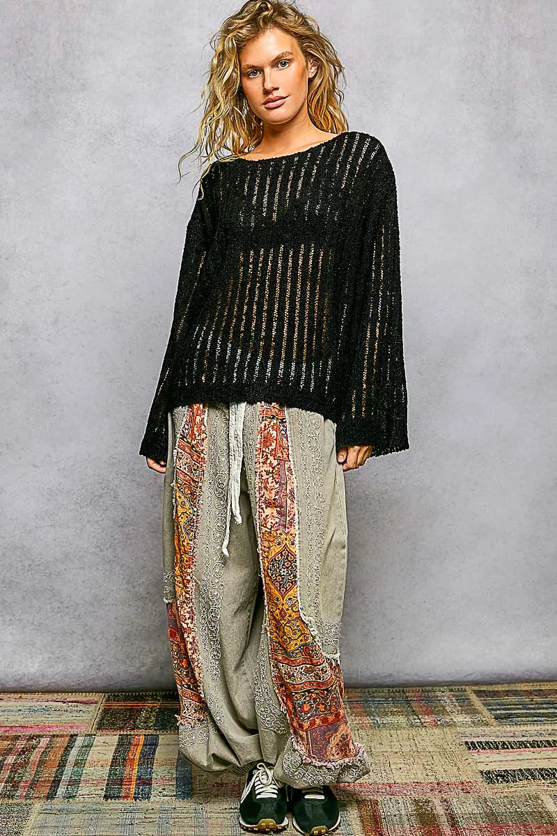 Black open-weave round-neck long-sleeve sweater, full-body view, textured knit.