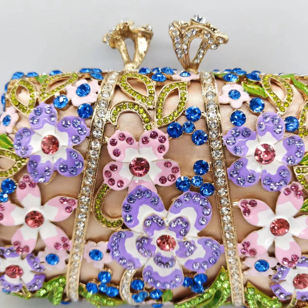 Close-up of jeweled floral clutch front panel with blue gems, purple flowers, and pink accents