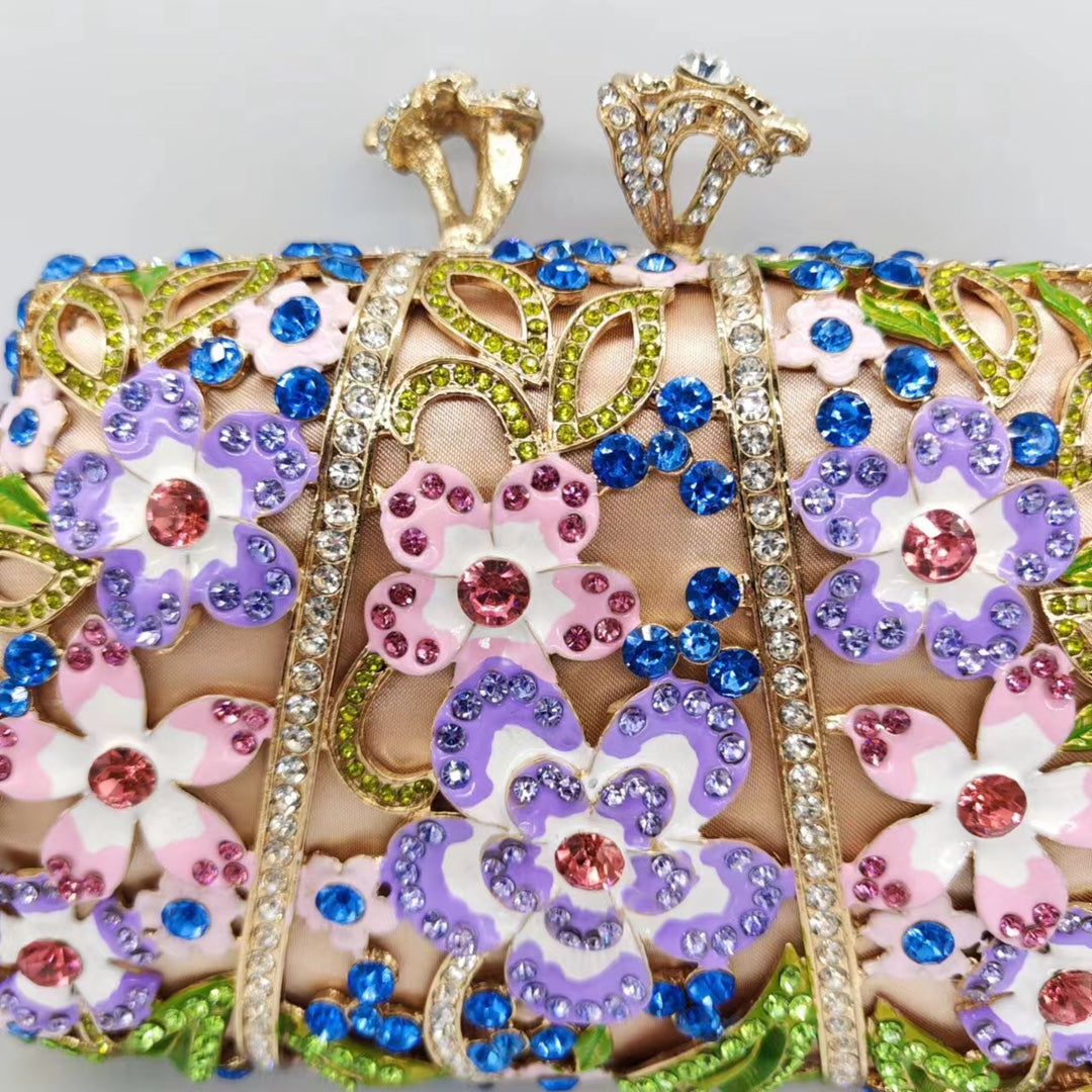 Close-up of jeweled floral clutch front panel with blue gems, purple flowers, and pink accents