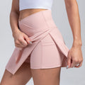 Pink yoga skirt shorts with pleated front drape and elastic waistband, mid-thigh length