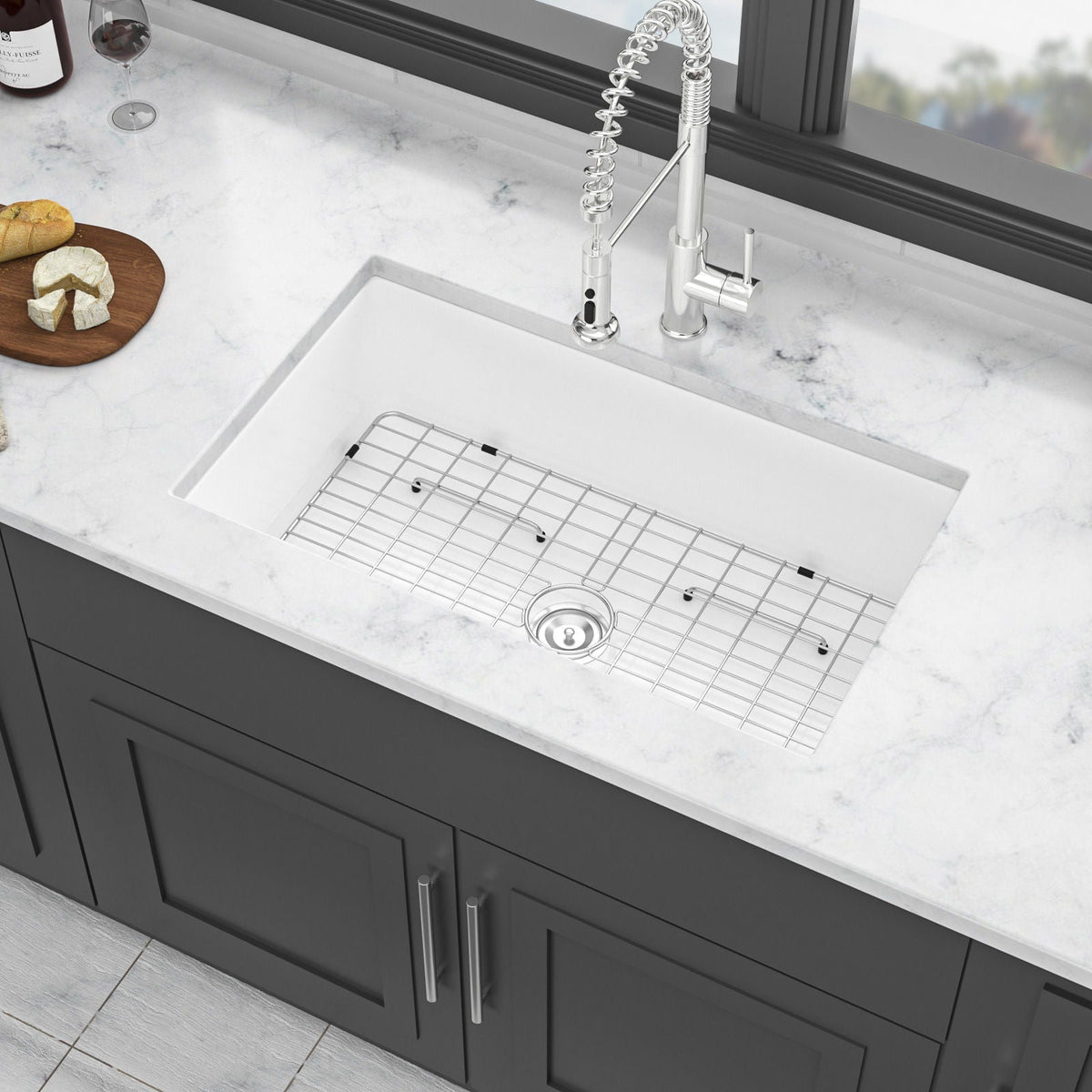 White ceramic single-bowl apron-front sink with rack grid and centered drain