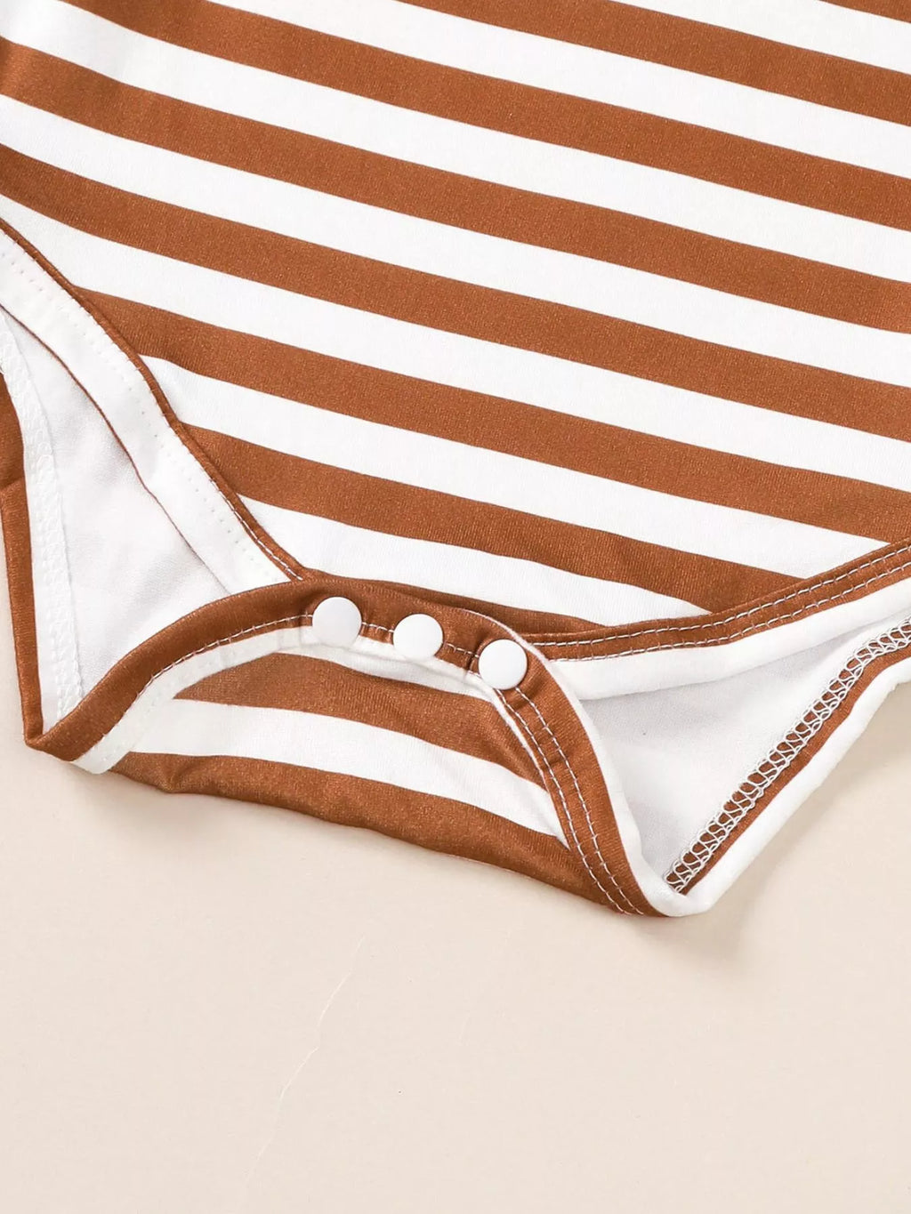 Striped long-sleeve bodysuit with snap buttons at crotch, white and dark brown