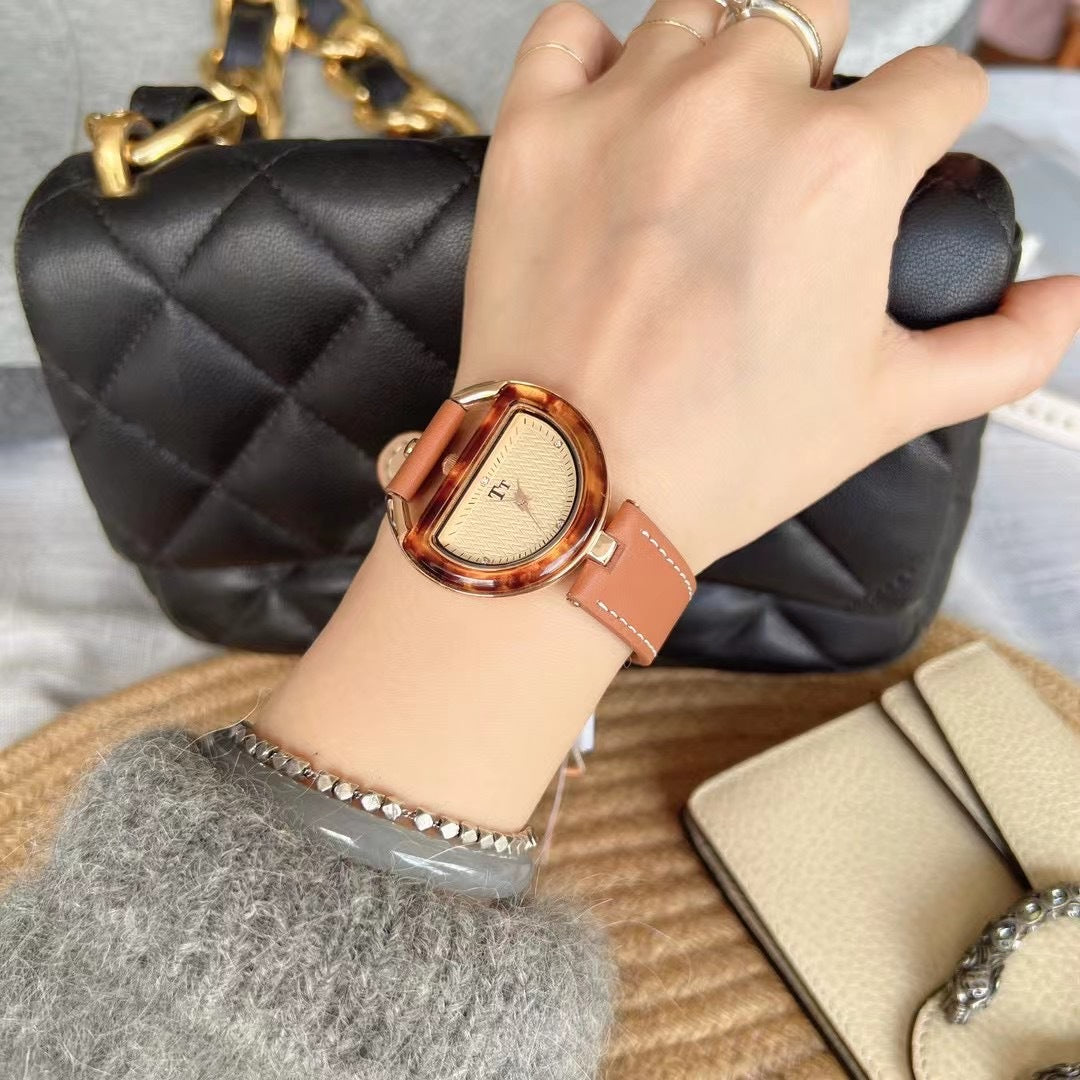 Women’s leather-strap watch with tan band and rose-gold oval case, light dial.