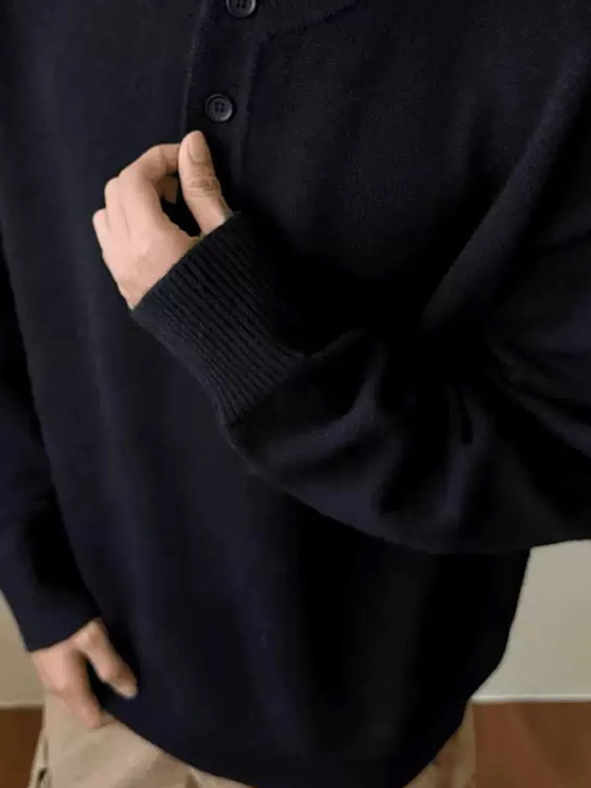 Dark drop-shoulder knit sweater with button placket and ribbed cuffs (worn)
