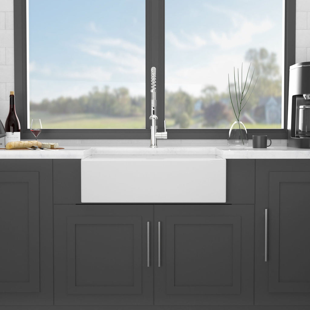 White ceramic farmhouse sink with single front apron and centered basin