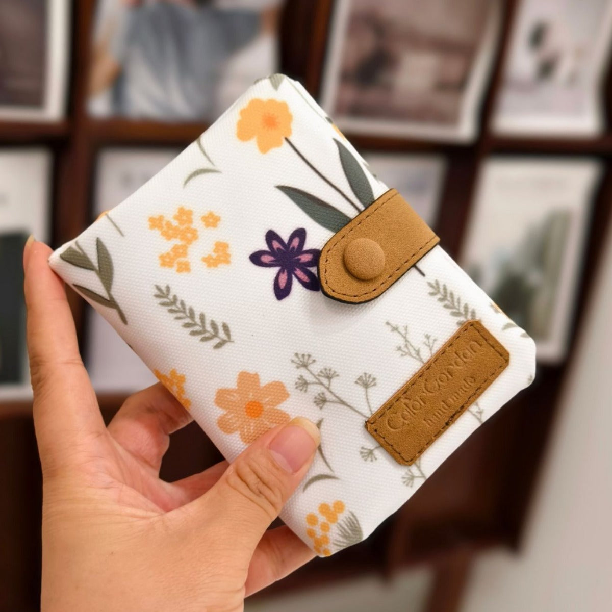 Printed tri-fold wallet with snap button, white background, floral leaf pattern, tan trim
