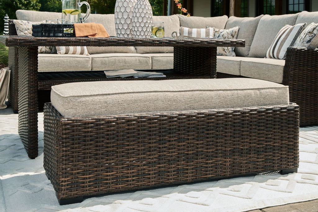 Outdoor sectional sofa and ottoman with dark brown wicker base and light beige cushion