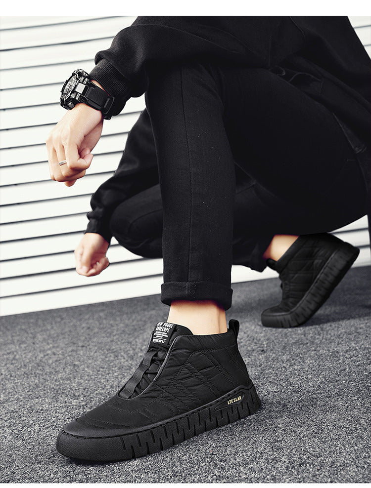Men's black high-top winter boots on a person, lace-up style with grippy tread