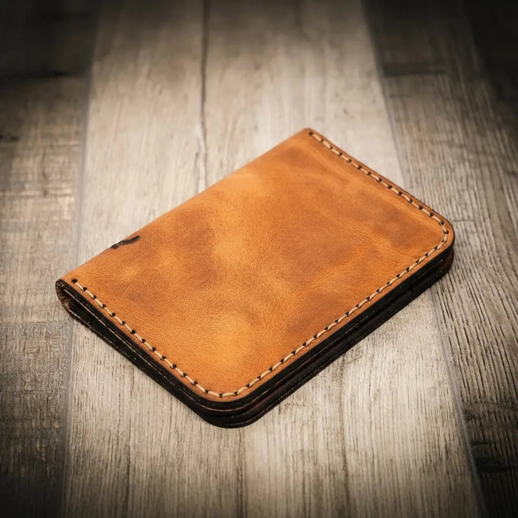 Closed tan leather vertical wallet with contrast stitching and rounded edges