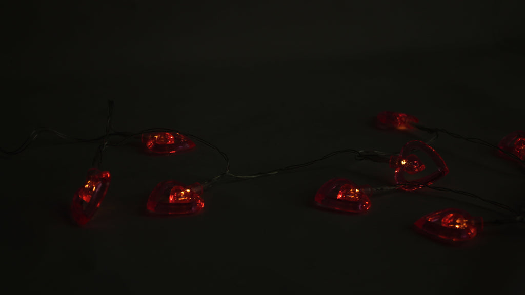 Red-glowing LED heart string lights with heart bulbs on a wire strand