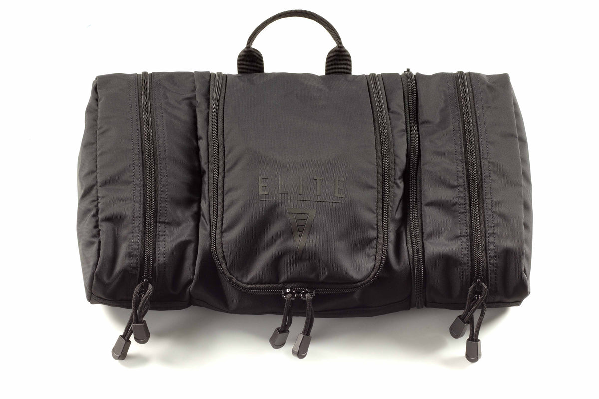 Dark toiletry kit with carrying handle and “ELITE 7” logo on front pouch