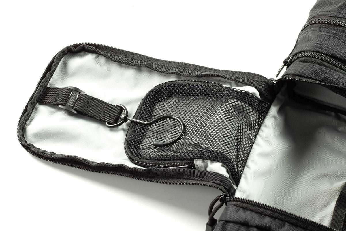 Inside dark toiletry kit showing zippered mesh pocket and elastic strap