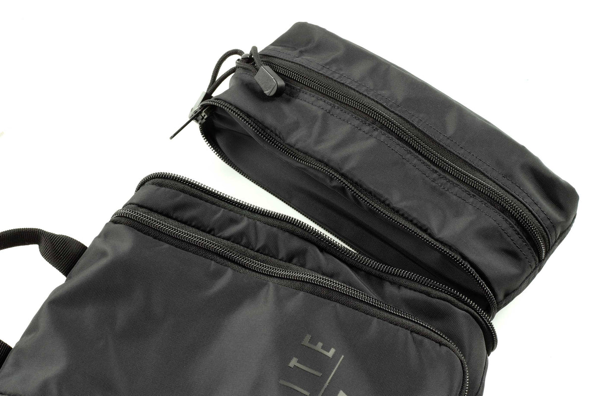 Side view of dark toiletry kit with two zip compartments and strap handles