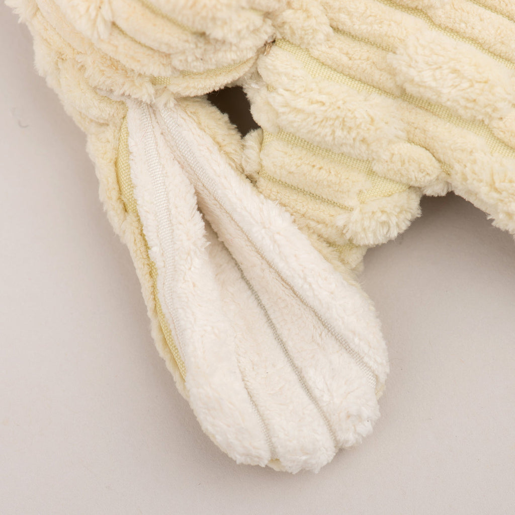 Close-up of cream plush fabric with ribbed, raised texture