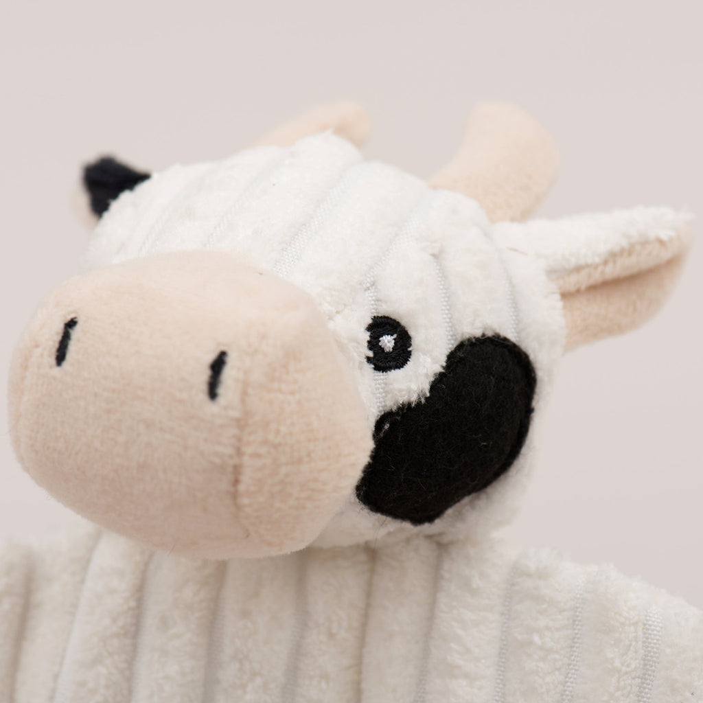 Close-up of white plush dog toy face with black nose and muzzle