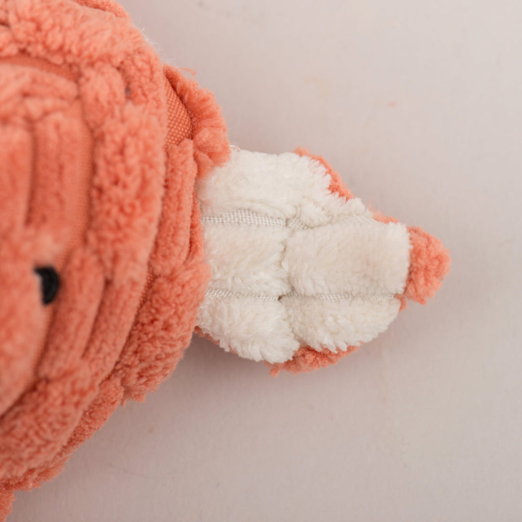 Close-up of rust plush toy arm and paw with white lining