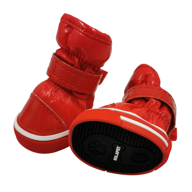 Red pet ski boots with hook-and-loop straps and textured white-trim rubber soles
