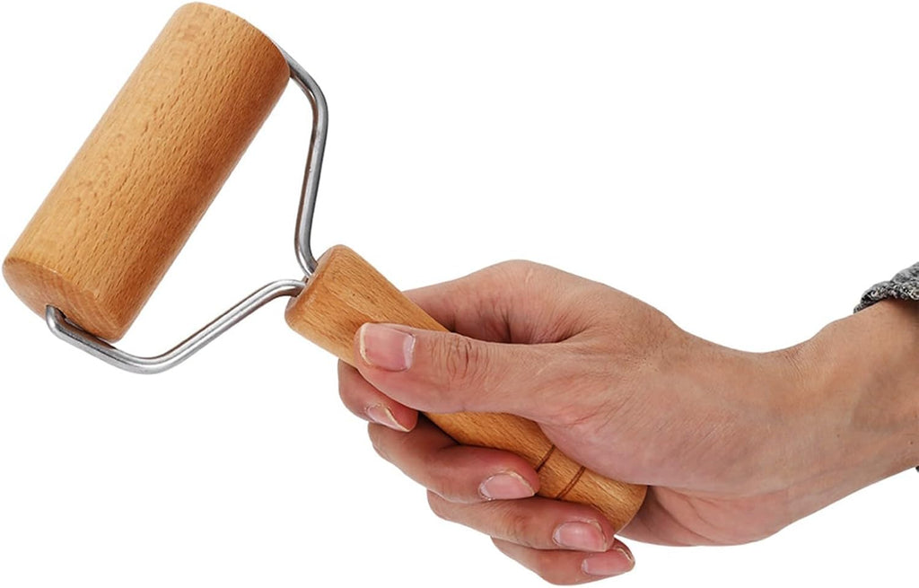 Wooden dough rolling pin with U-shaped metal handle held in hand