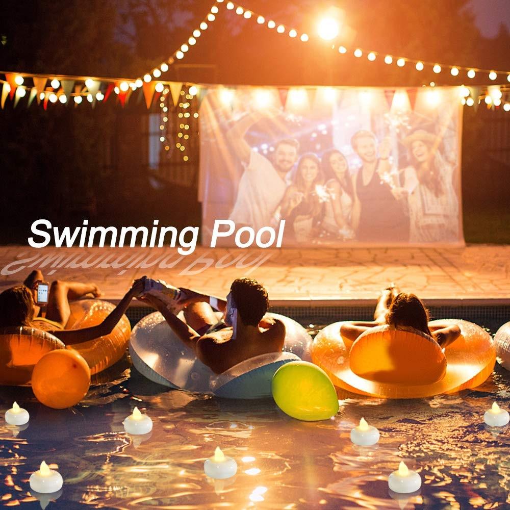 LED floating tea lights with warm yellow flames on a swimming pool surface