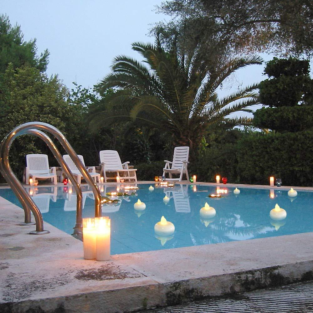 Floating LED tea light candles along a pool edge with warm yellow glow